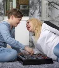 Lapsi ja vanhempi pelaavat kodin lattialla.